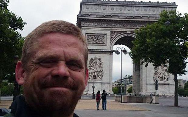 Żebrak używa czytnika kart płatniczych do zbierania datków od bogatych turystów