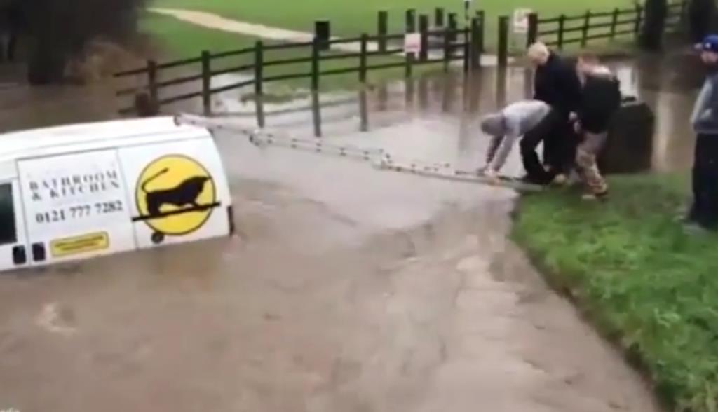 Zobacz jak mężczyzna wspiął się po drabinie na dach zalanego samochodu